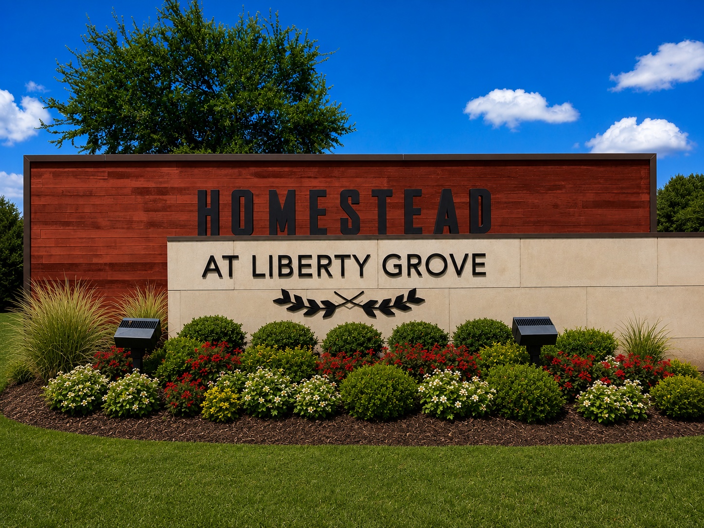 Sign reading 'HOMESTEAD AT LIBERTY GROVE' set in a stone and wood landscape with red-brown panels and trimmed shrubs, under a blue sky.